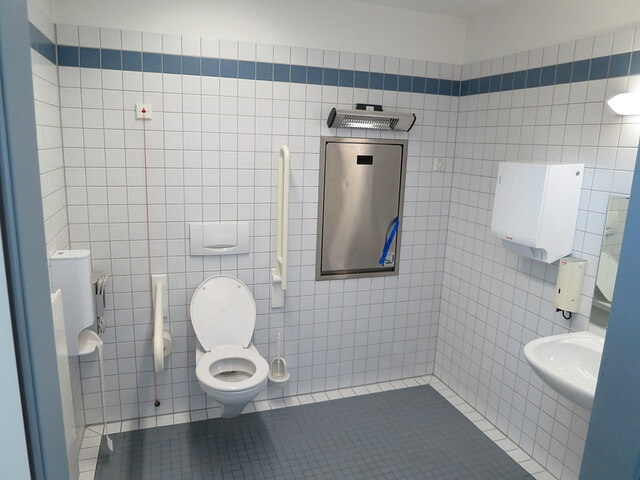 Person beim Schrubben der Toilette mit einer Bürste