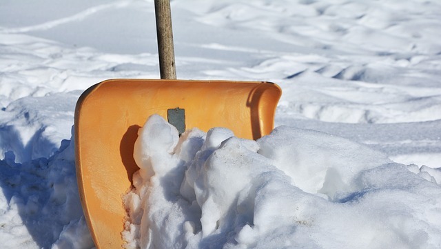 Arbeiter entfernt Schnee während der Gebäudereinigung im Winter